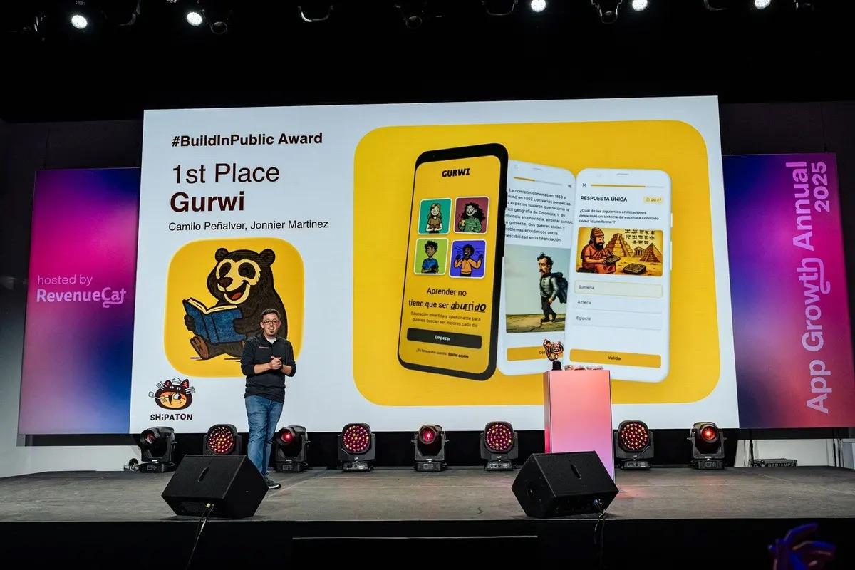 Picture of man on stage, with a screen behind them showing an app called Gurwi
